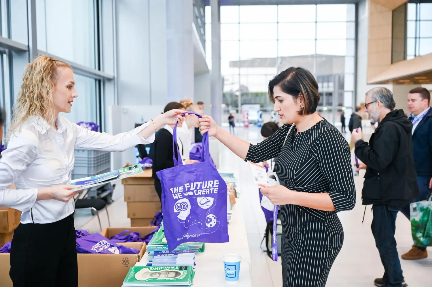 An attendee collects her welcome bag at the European Collaboration Summit 2025